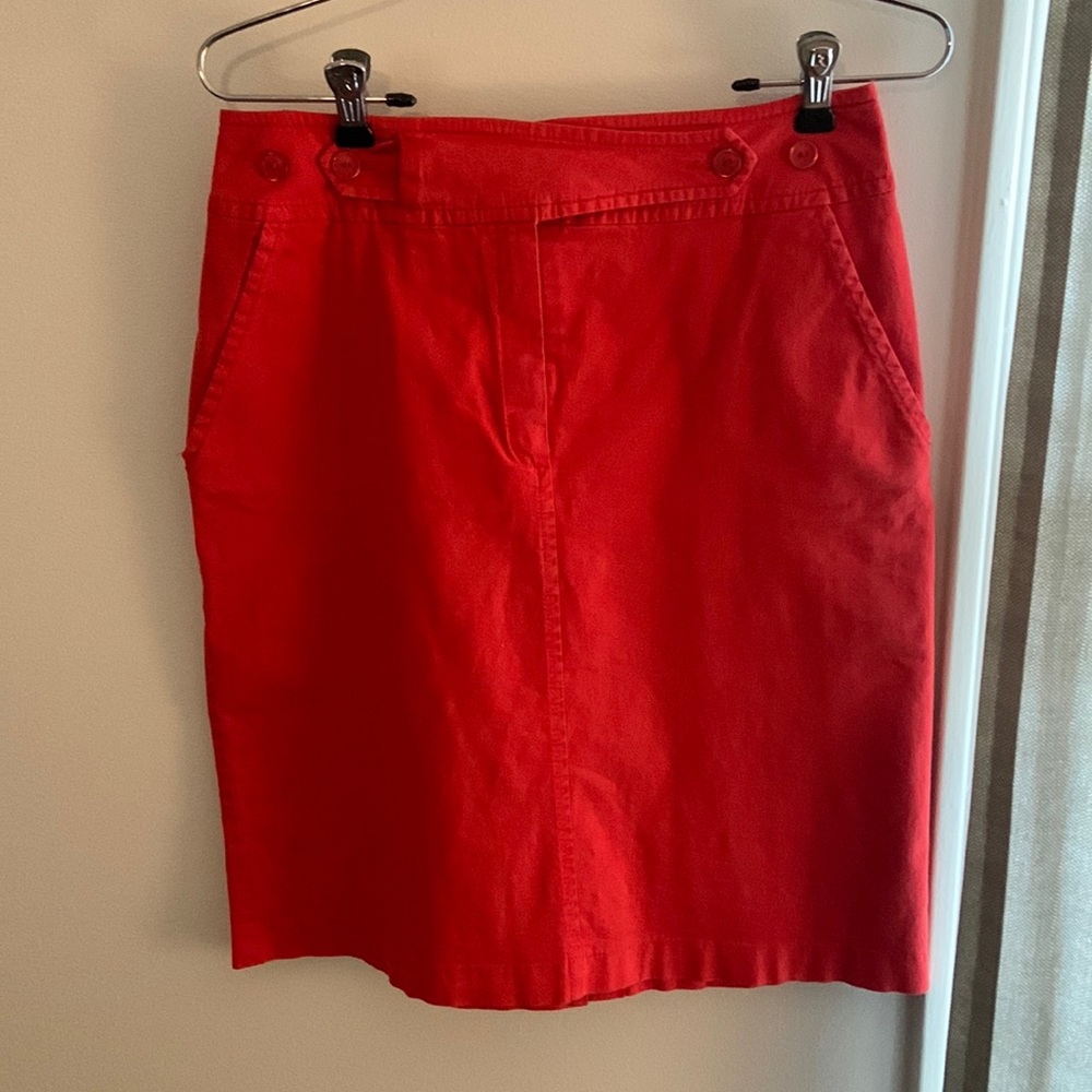 Red skirt with button details and pockets. Size 8. Runs small.